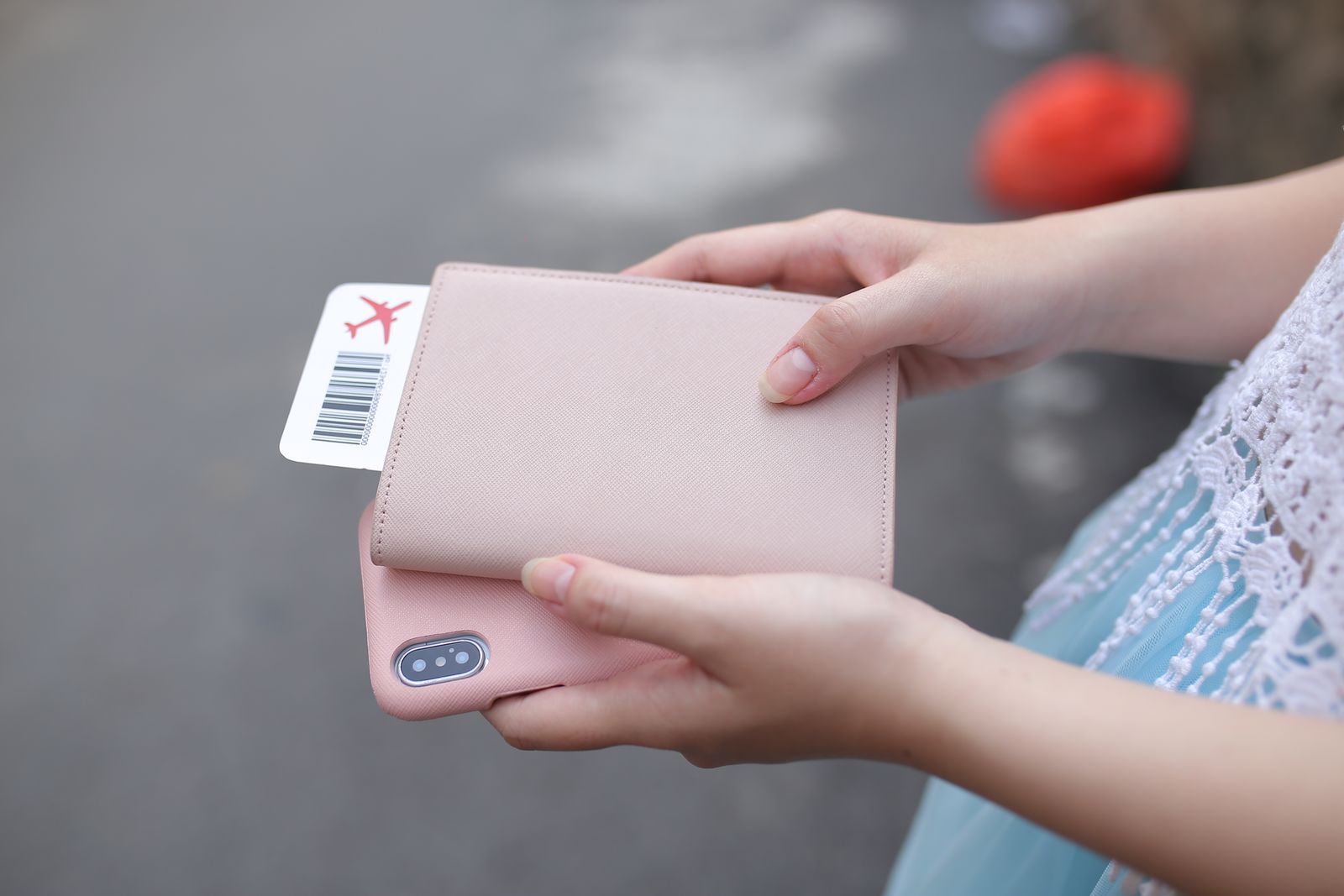 Person holding a smartphone and passport wallet