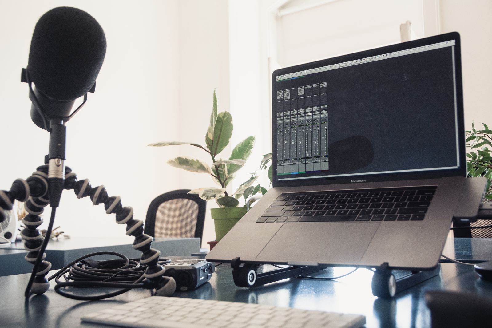 Laptop and microphone in a recording workspace