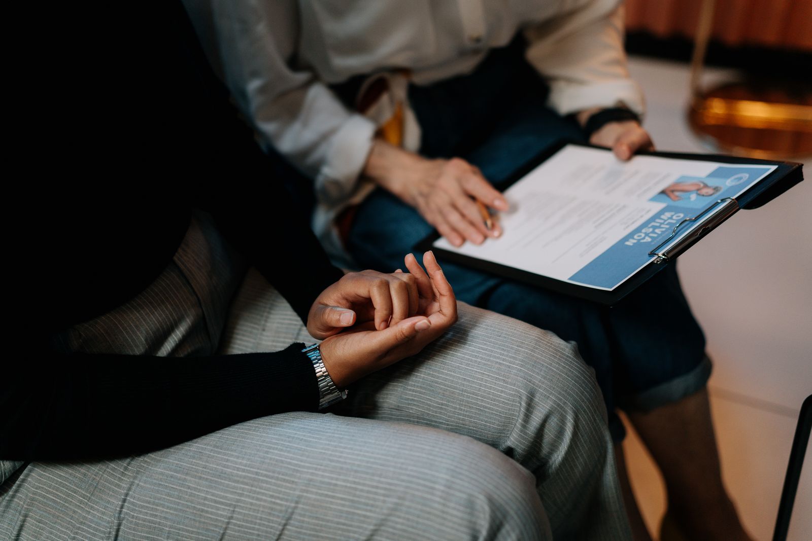 Person holding a clipboard with a resume during an interview