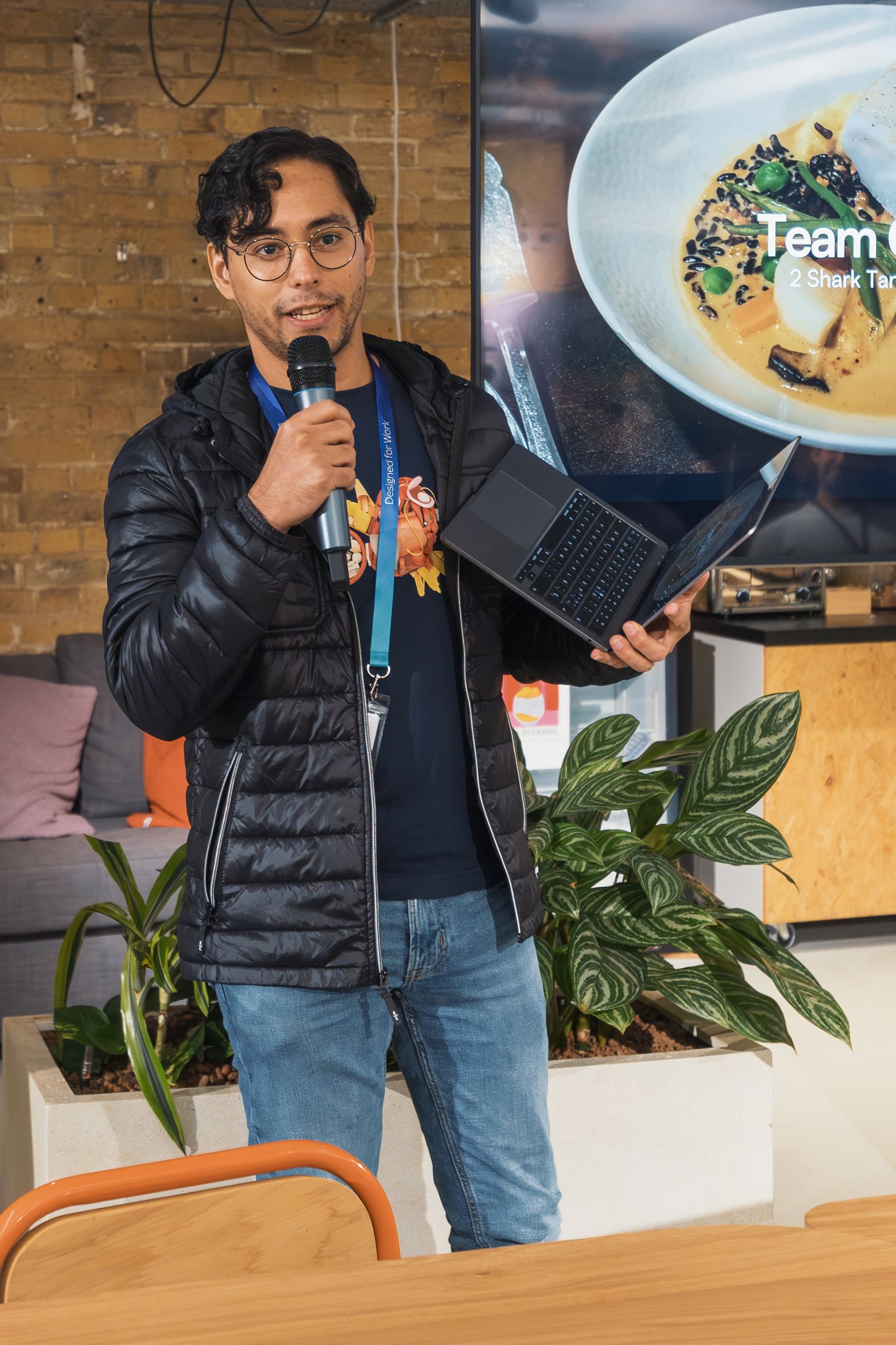 Presenter using a laptop and microphone