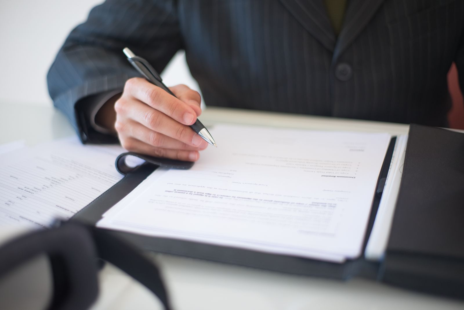 Hand signing a business document