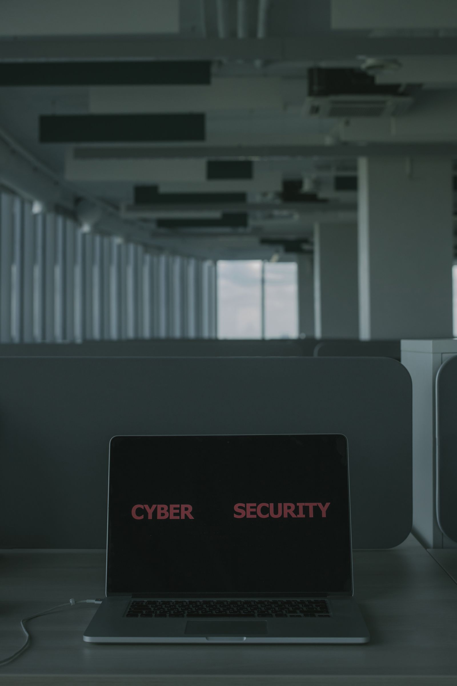 Laptop displaying a cyber security message in a modern office